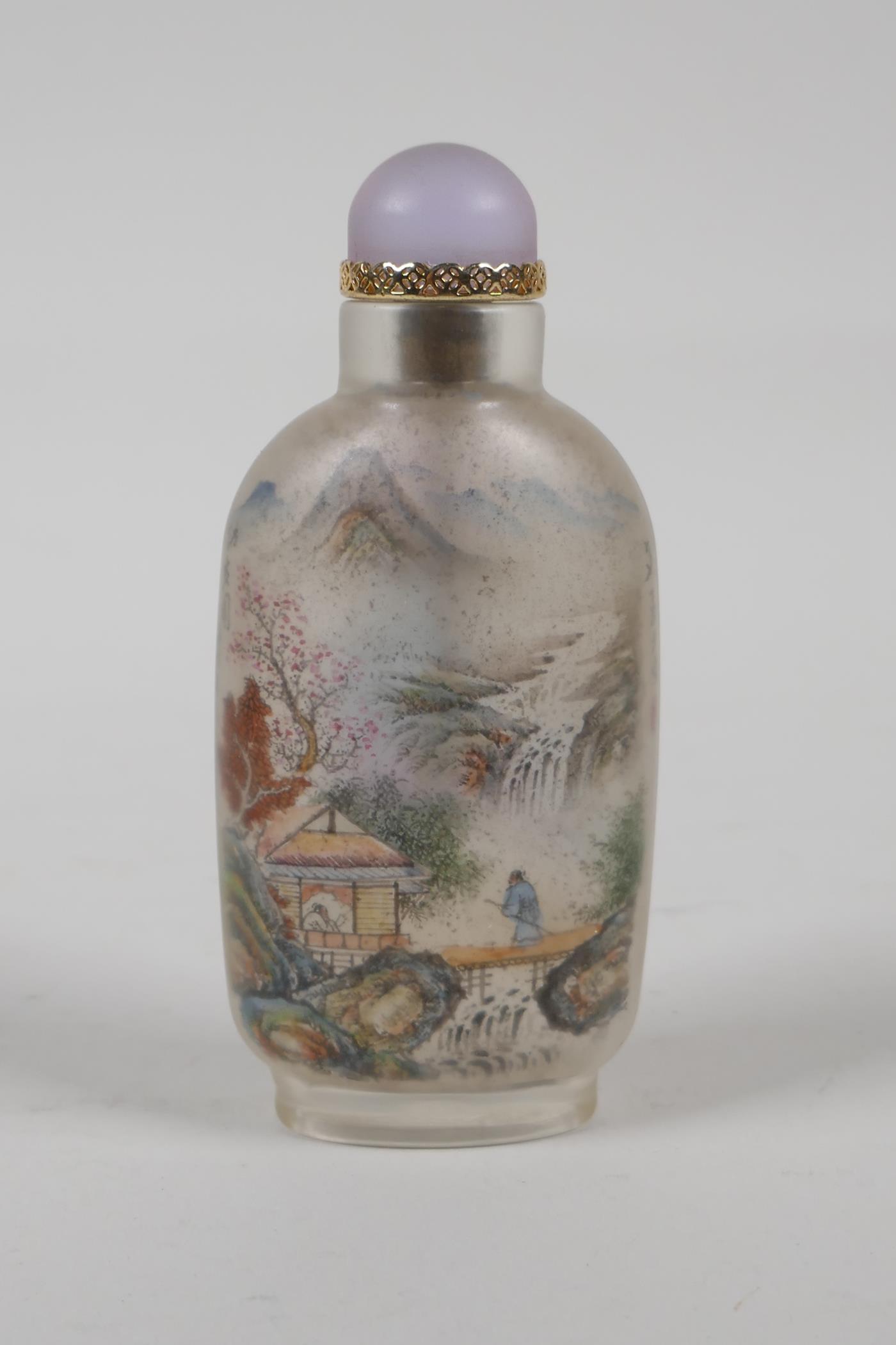 A Chinese reverse decorated glass snuff bottle depicting figures in a river landscape, and scribes