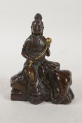 A Chinese filled bronze figure of Quan Yin seated on an elephant and carrying a gilt lotus flower,