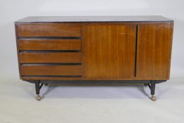 A mid-century mahogany sideboard with ebonised detail, comprising two cupboards and four drawers,