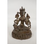 A Sino Tibetan gilt bronze of a female deity seated on a lotus throne, 7" high