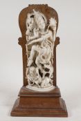 A C19th finely carved Indian ivory figure of Shiva, mounted on a rosewood base, 10" high