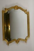 A brass easel backed mirror with swag shell decoration, 15" x 20"