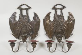 A pair of bronze Gothic style two branch wall sconces in the form of vampire bats, 13½" long