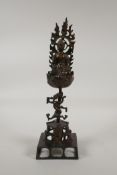 A Nepalese/Tibetan bronze figure of Buddha seated on a lotus flower raised on a dragon form stem,