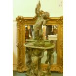 A vintage lead fountain with three putti supporting a bowl and a putti above