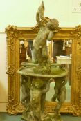 A vintage lead fountain with three putti supporting a bowl and a putti above