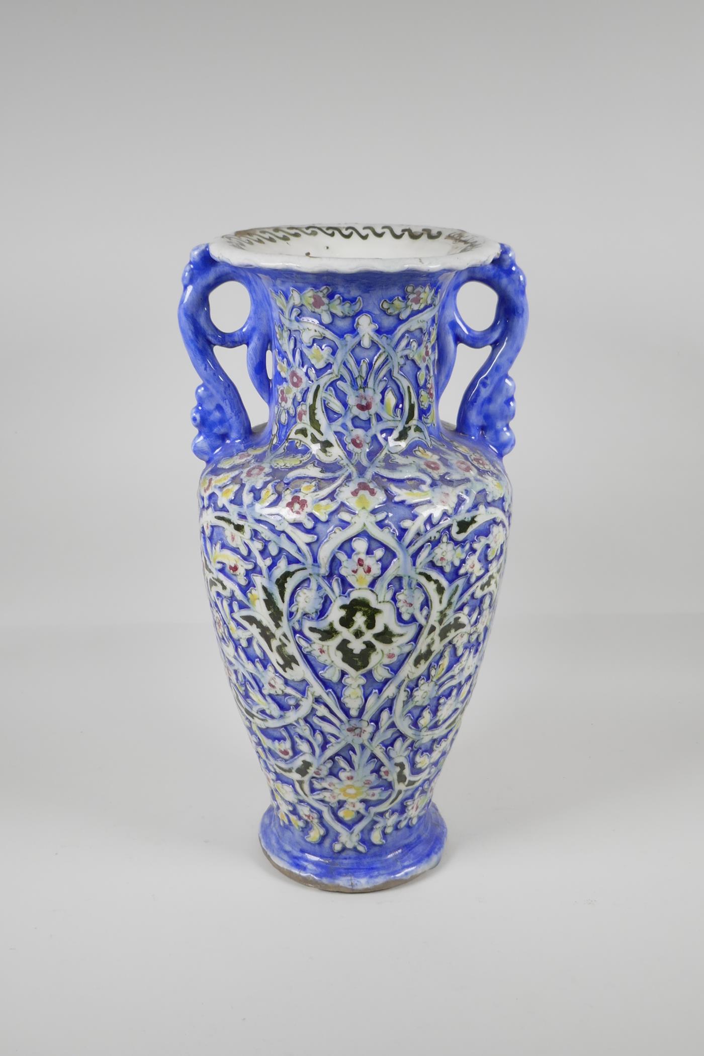 A Persian blue ground pottery two handled vase, with Iznik style raised polychrome scrolling - Image 3 of 7