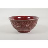 A Chinese sang de boeuf glazed porcelain bowl with raised dragon and phoenix decoration, 6 character