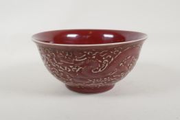 A Chinese sang de boeuf glazed porcelain bowl with raised dragon and phoenix decoration, 6 character