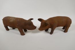 A pair of cast iron garden figures of piglets, 11" long