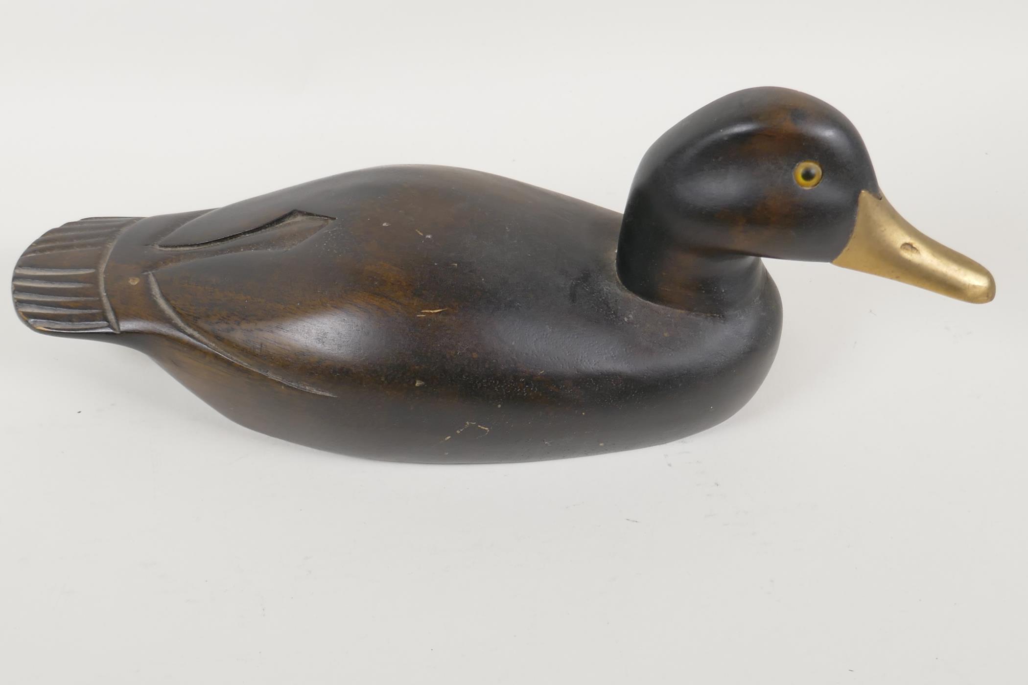 A carved wood decoy duck with glass eyes, 14" long
