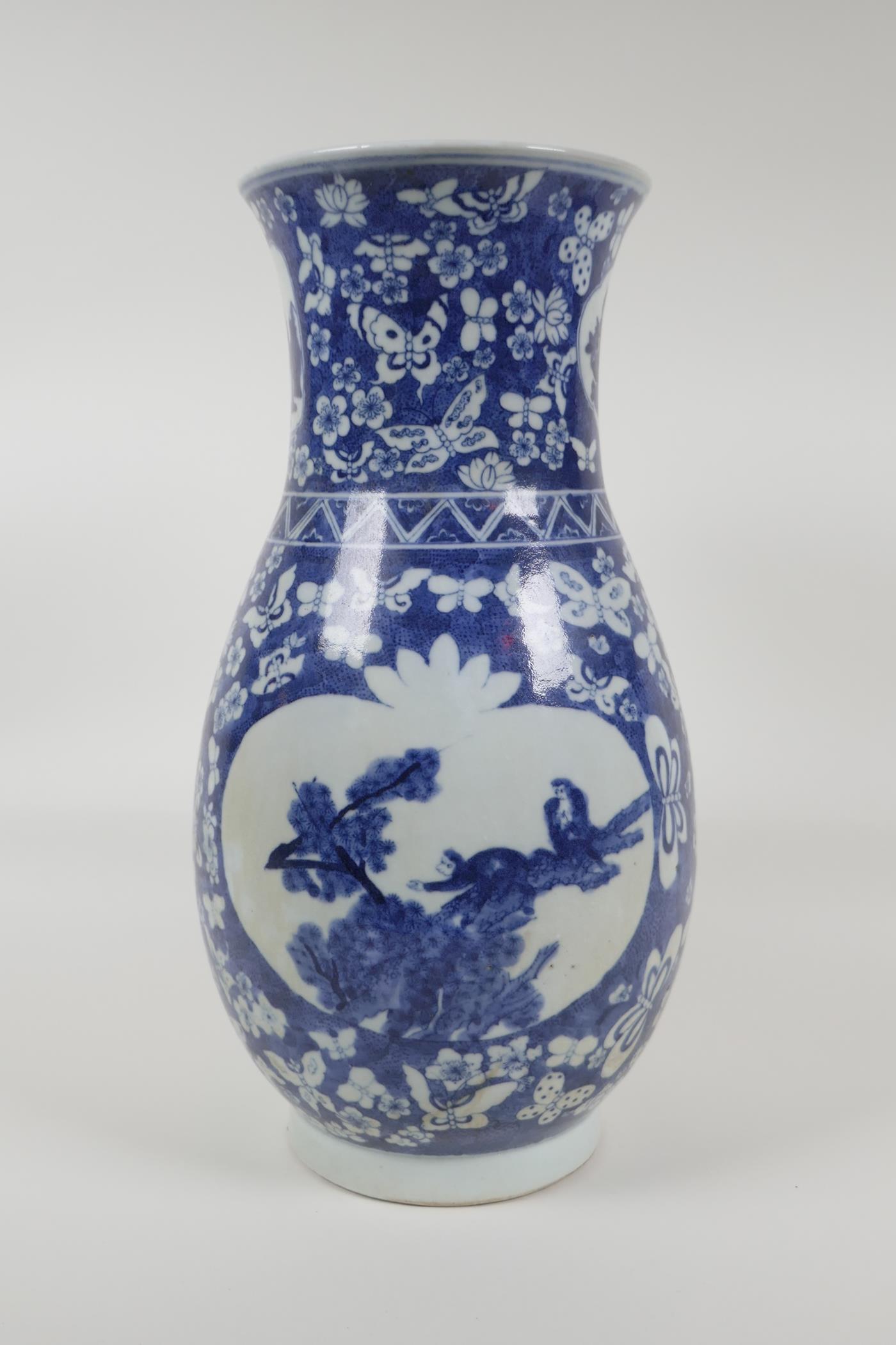 An early C20th Chinese blue and white porcelain vase with two decorative panels depicting birds