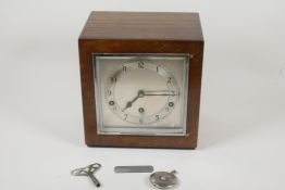 An Art Deco inlaid oak cased Westminster Chimes mantel clock with silvered dial and Arabic numerals,