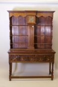 An early C20th oak Jacobean style dresser, the rack fitted with a fusee clock with brass dial, and