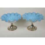 A pair of blue over white milk glass fruit bowls of frilled design on silver plated pedestal