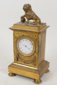 An ormolu mantel clock of architectural form, surmounted by a figure of a dog and ball, with watch