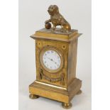 An ormolu mantel clock of architectural form, surmounted by a figure of a dog and ball, with watch