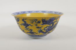 A Chinese Ming style yellow ground porcelain bowl with blue and white dragon and flaming pearl