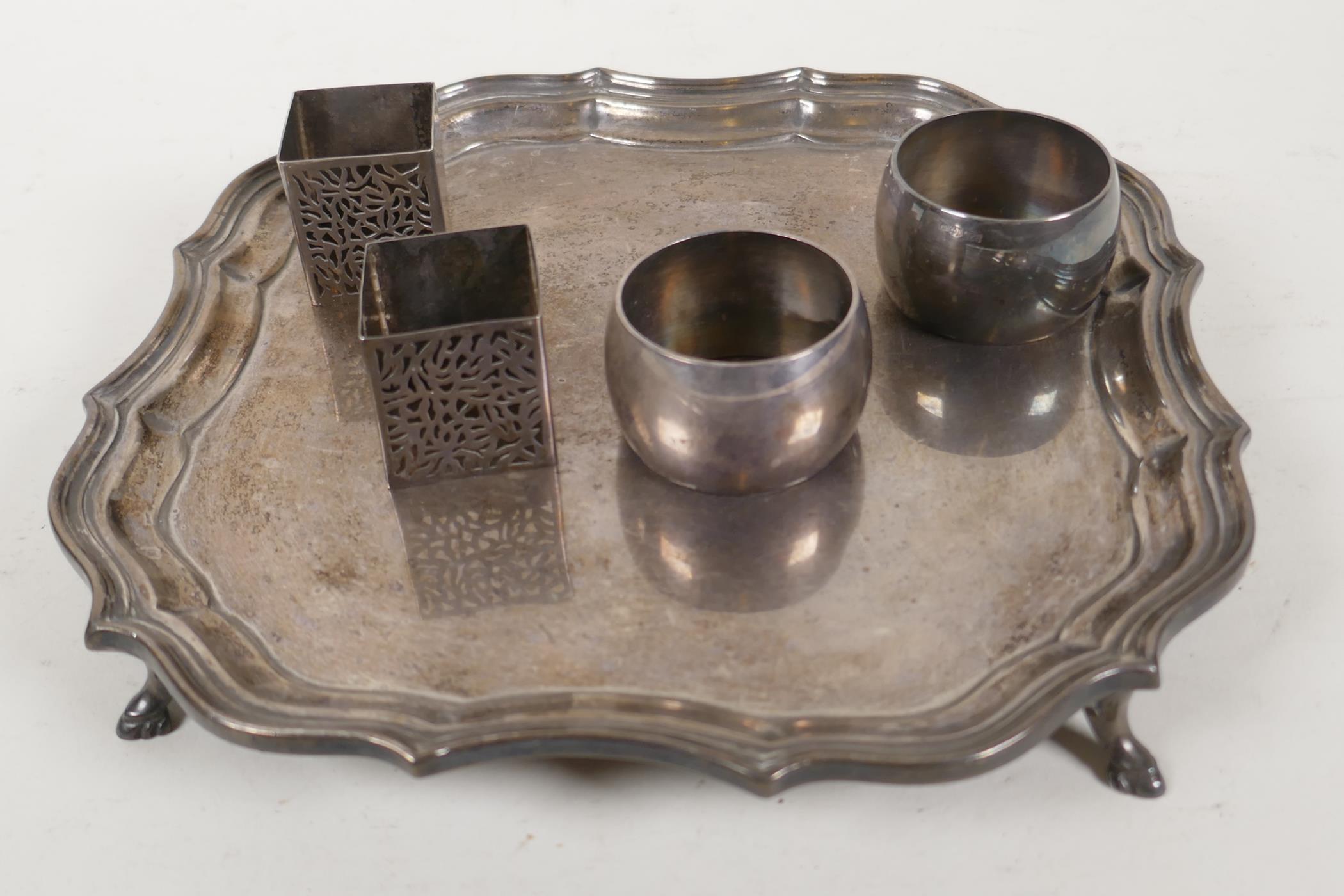 A hallmarked silver card tray with gadrooned rim, on four hoof feet, and two pairs of silver