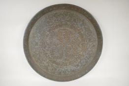 A heavy brass tray engraved with Islamic geometric patterns, and calligraphy script to the rim, 23½"