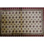 An ivory ground full pile Kashmir rug with Bokhara design and red border, 49" x 75"