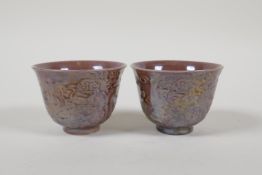 A pair of Chinese purple lustre glazed porcelain tea bowls with raised dragon decoration, 6