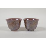 A pair of Chinese purple lustre glazed porcelain tea bowls with raised dragon decoration, 6