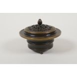 A Chinese bronze censer and cover, raised on tripod supports, the pierced cover with auspicious