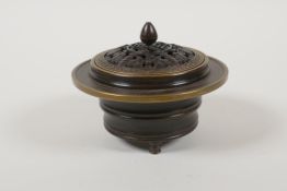 A Chinese bronze censer and cover, raised on tripod supports, the pierced cover with auspicious