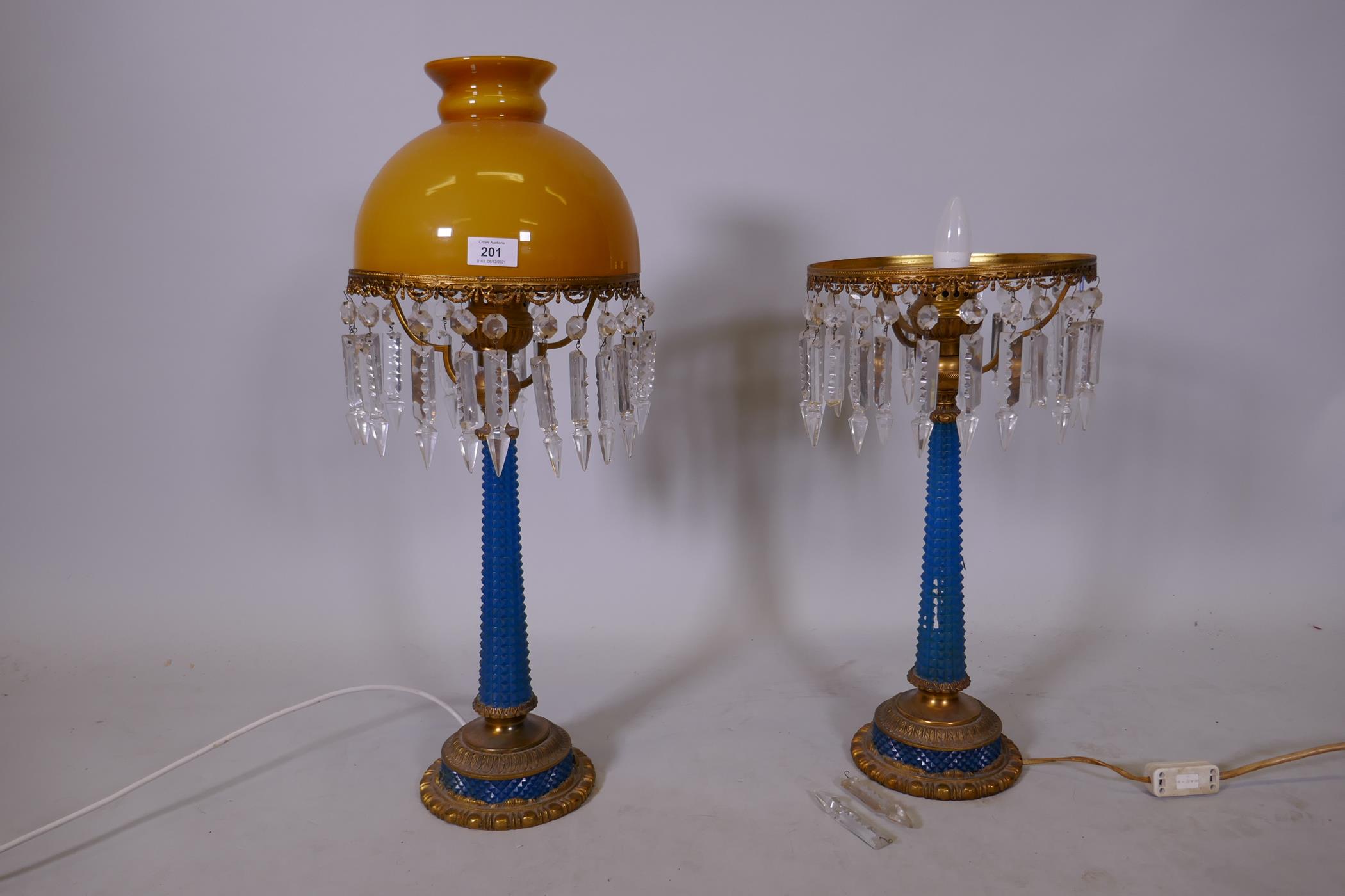 A pair of blue glass and brass mounted lustre table lamps, lacking a shade and seven drops, 26" high