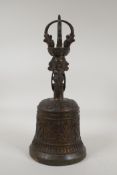 A Tibetan gilt bronze ceremonial bell, the handle with Buddha head and vajra decoration, 13½" high