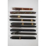 A collection of early 'Swan' Mabie Todd fountain pens, including a wood effect pattern self-