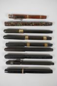 A collection of early 'Swan' Mabie Todd fountain pens, including a wood effect pattern self-