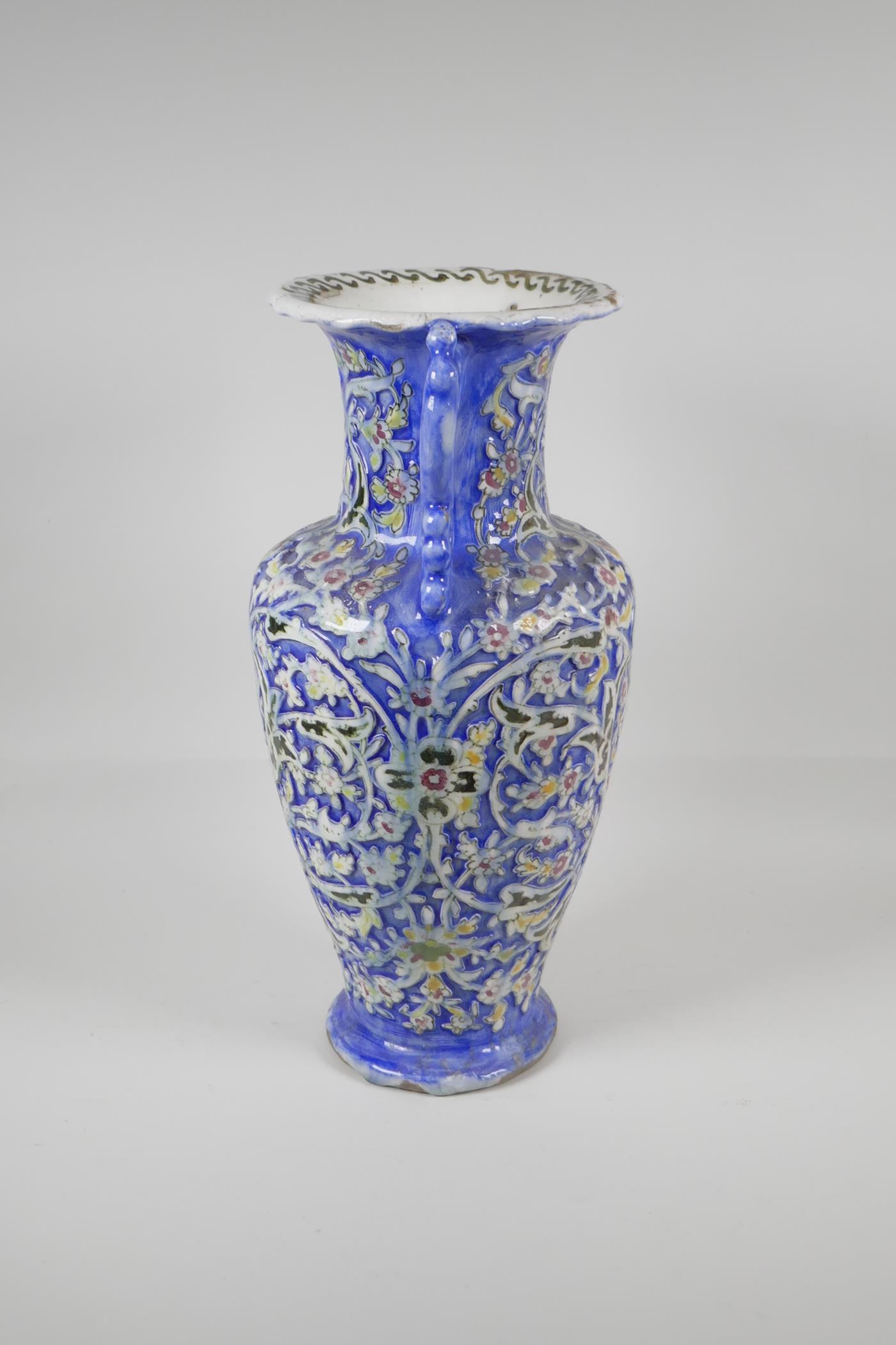 A Persian blue ground pottery two handled vase, with Iznik style raised polychrome scrolling - Image 4 of 7