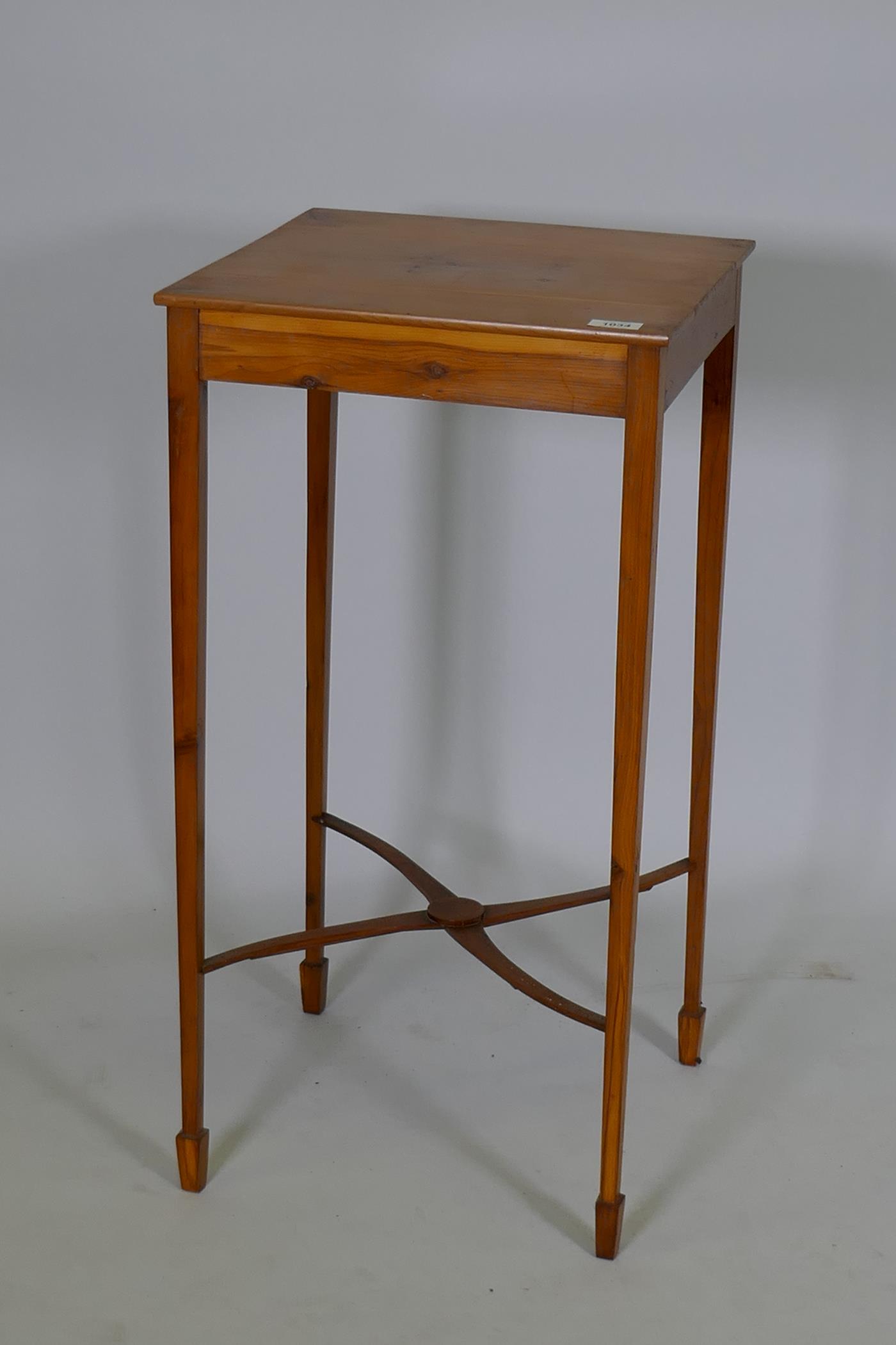 A mid C20th bespoke yew wood lamp table, raised on slender tapering supports united by shaped