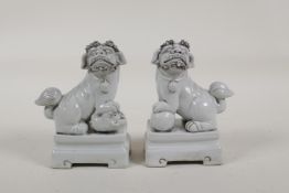 A pair of blanc de chine porcelain pen/brush holders in the form of temple lions, 5" high