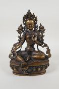 A Sino Tibetan bronze figure of a deity seated on a lotus throne, 8" high