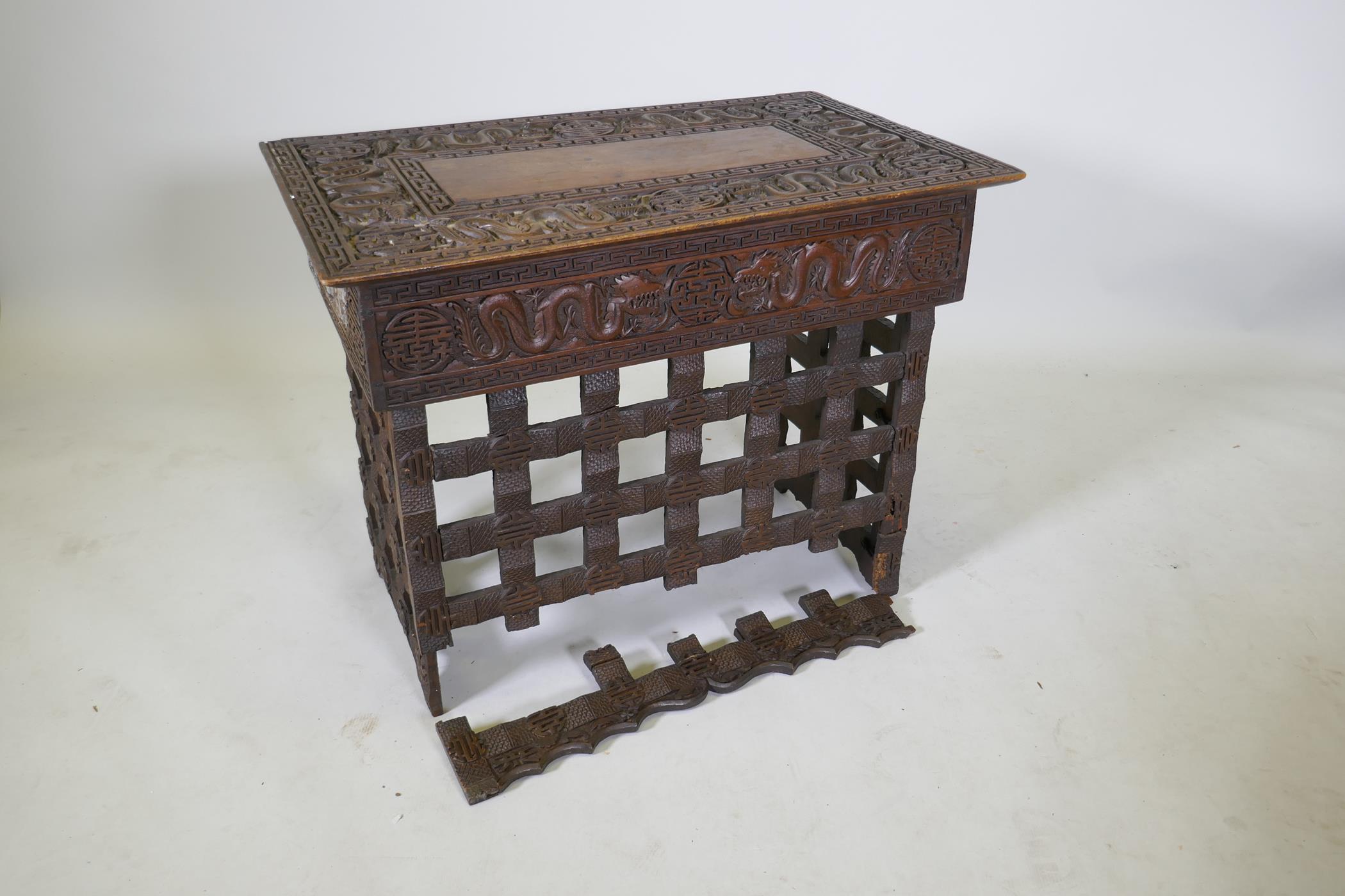 A C19th Chinese carved hardwood travel desk with a pierced folding base, decorated with dragons - Image 5 of 7