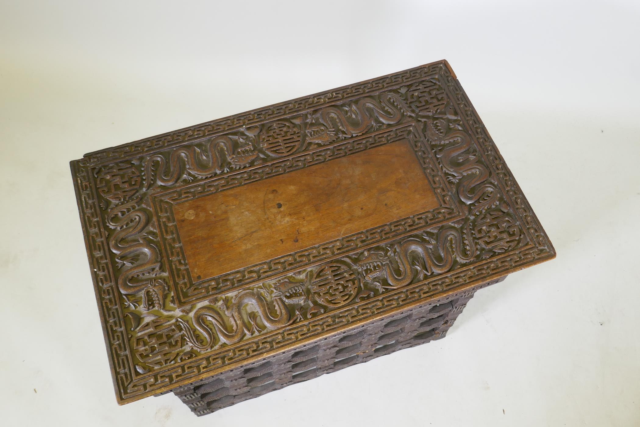 A C19th Chinese carved hardwood travel desk with a pierced folding base, decorated with dragons - Image 3 of 7