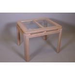 A contemporary blonde beechwood coffee table with inset glass top, 27" x 27" x 21"