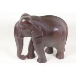 An Oriental carved hardwood figure of an elephant, 12" high