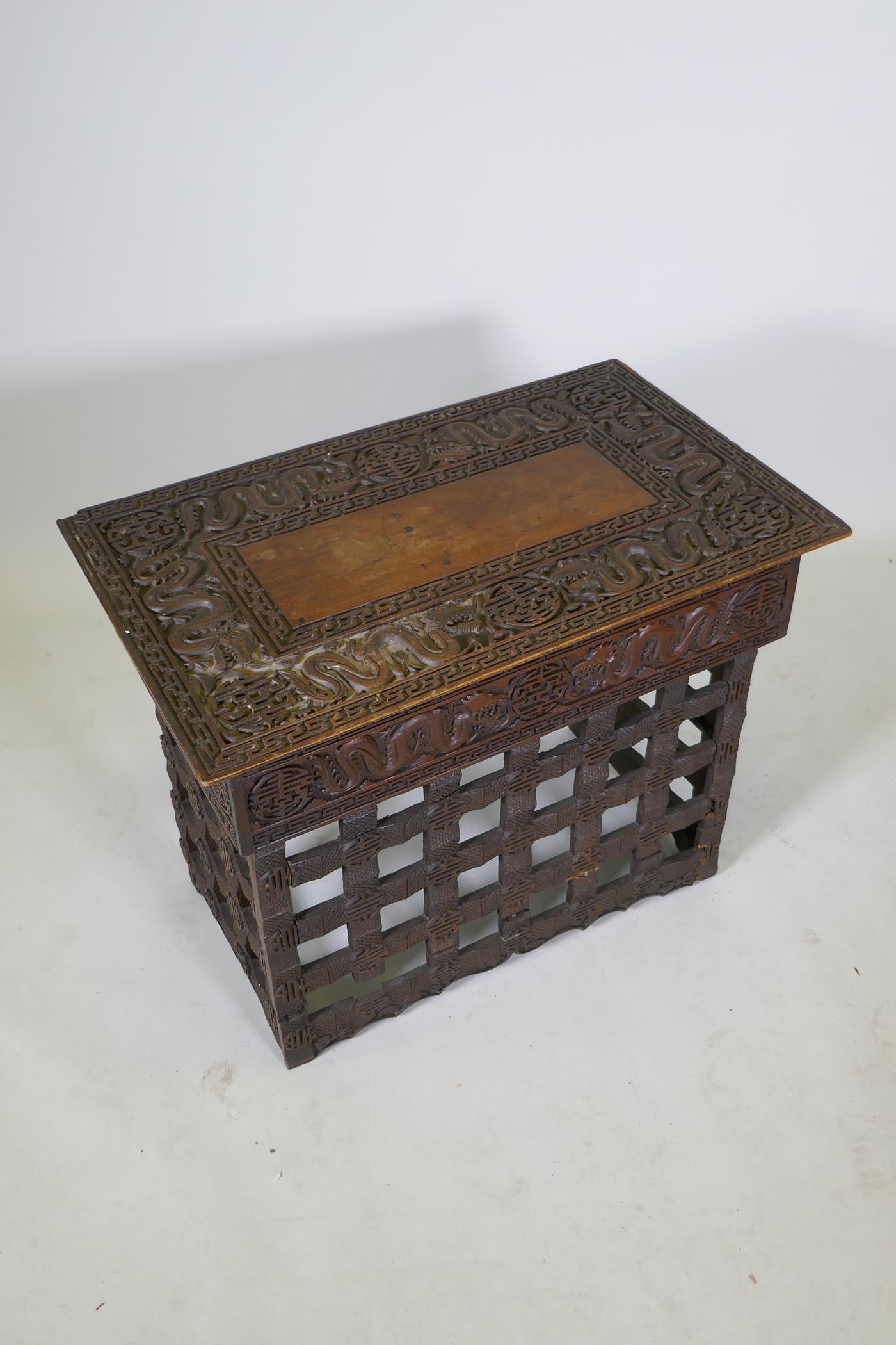 A C19th Chinese carved hardwood travel desk with a pierced folding base, decorated with dragons - Image 2 of 7