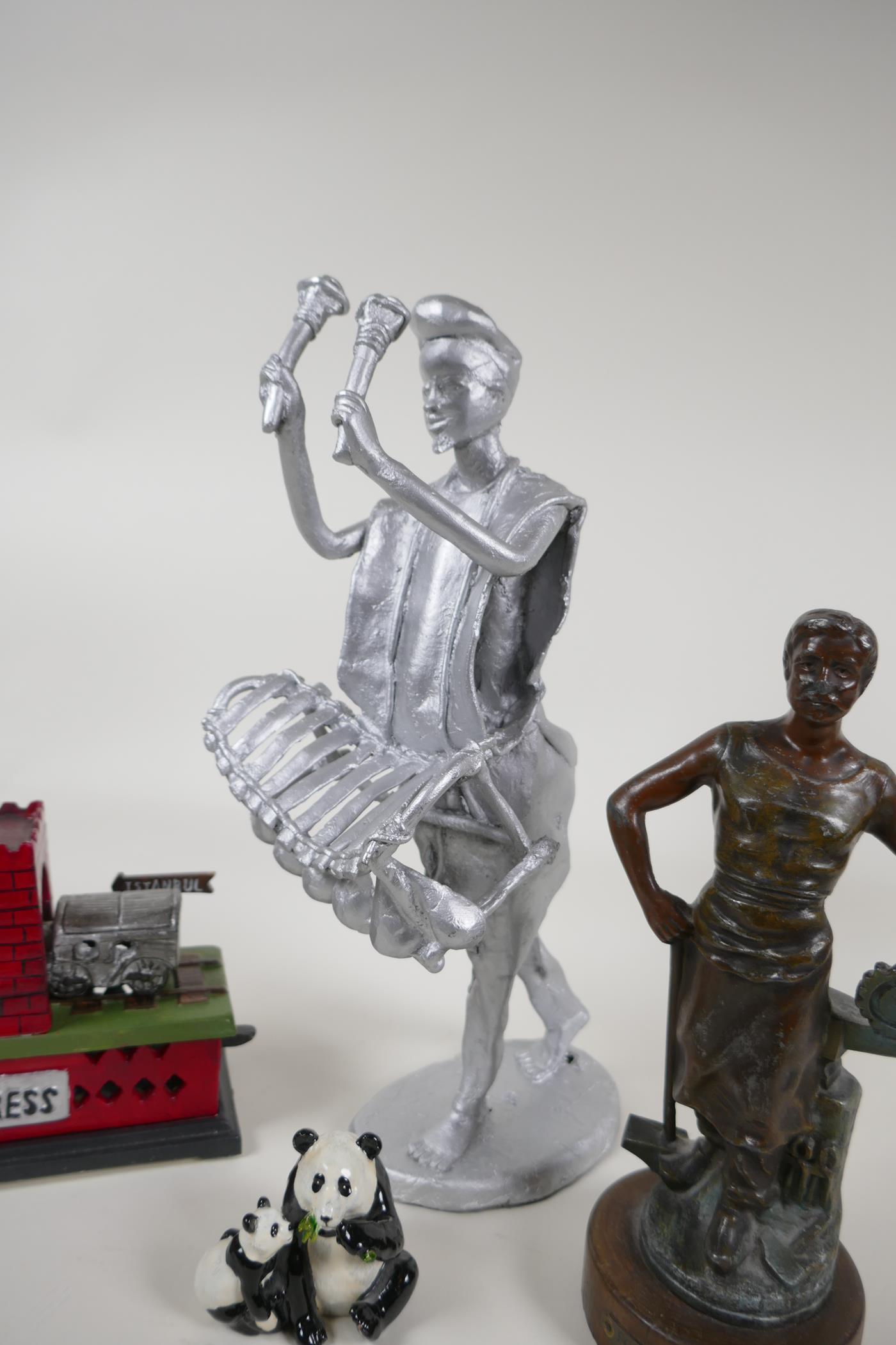A bronzed spelter figure of a foundry worker, and iron trick train money box, a painted metal figure - Image 5 of 5