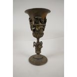 A cast iron vase decorated with fruiting vines, 11" high