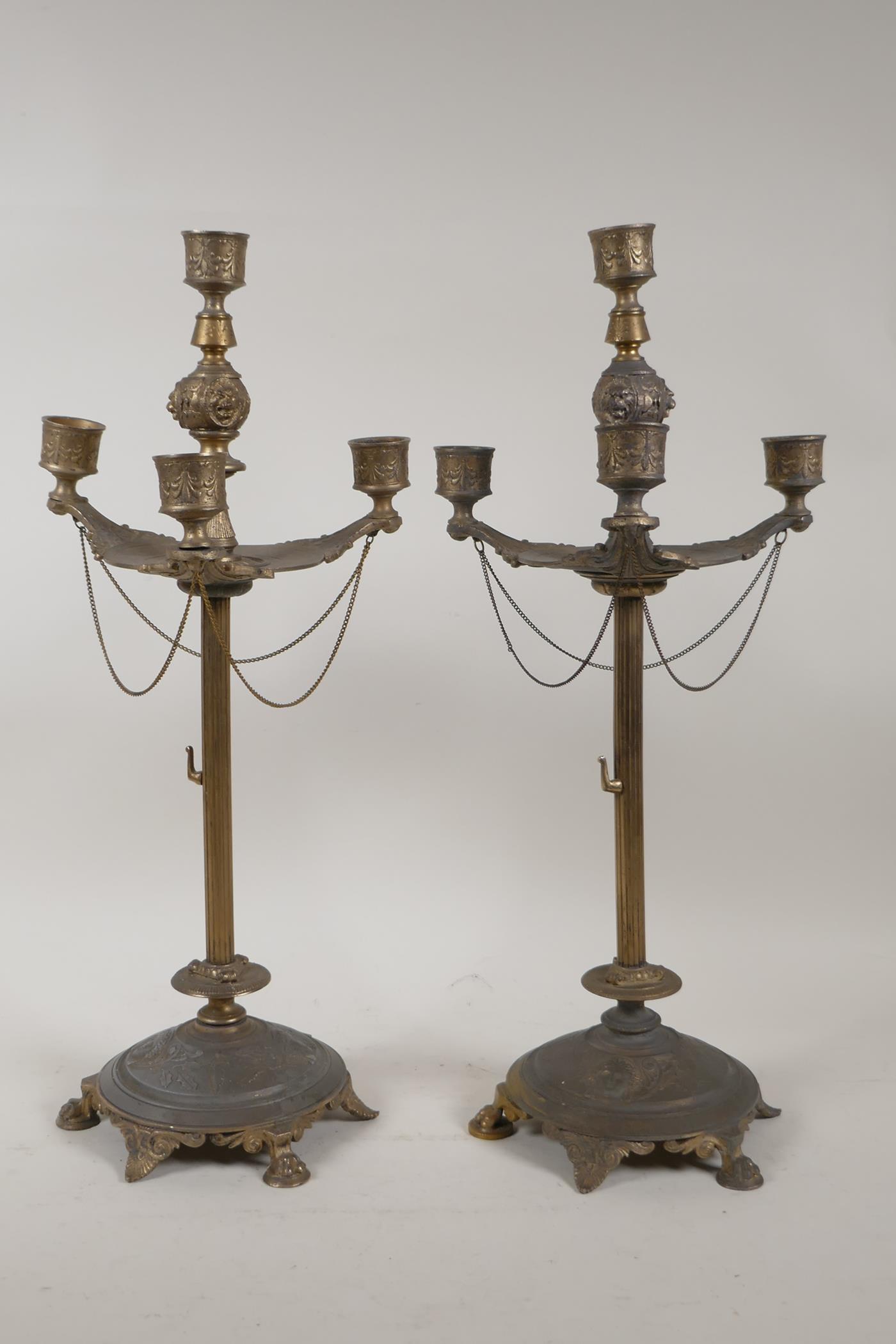 A pair of gilt metal three branch candlesticks of classical form, 17" high