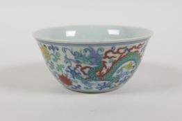 A Doucai porcelain tea bowl with dragon and lotus flower decoration, Chinese 6 character mark to