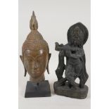 A Tibetan bronze Buddha head, 10" high, and a carved stone figure of Siva