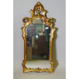 An Italian giltwood wall mirror with pierced and carved frame, early C20th, 38" x 18"
