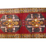 A full pile hand woven Persian runner with a black medallion design on a rich red field, 150" x 41"