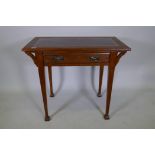 An Arts and Crafts oak desk with single drawer and inset leather top, raised on square tapering